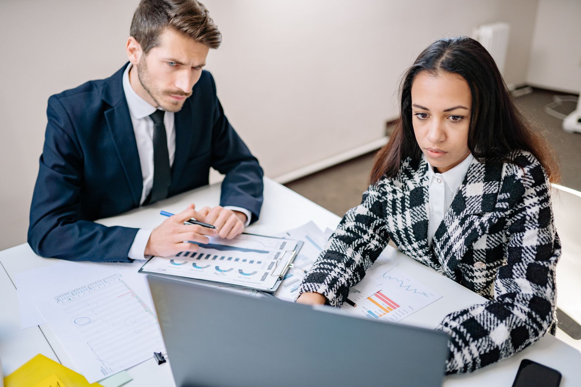 A finance team reviewing accounts on a laptop in a bright office
